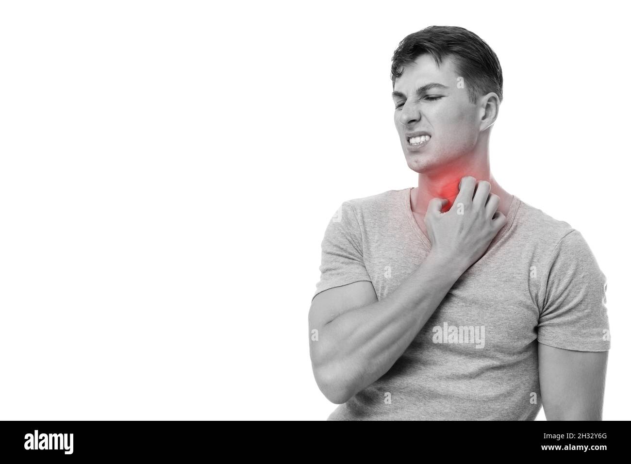 Triste jeune homme européen se grattant le cou souffrant d'eczéma, mis en évidence en rouge, photo monochrome, isolé sur fond blanc.Soins de santé et Banque D'Images