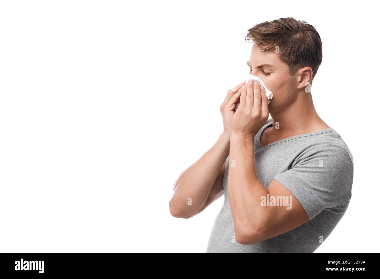 Millennal attrayant caucasien gars souffrant des premiers symptômes de la grippe et du froid, nez liquide, coups, sensation de malaise, isolé sur fond blanc, fr Banque D'Images