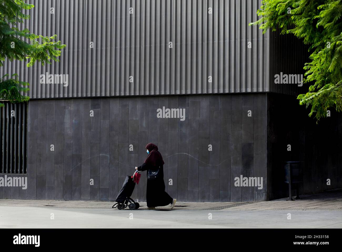 Femme arabe poussant le chariot de shopping, Barcelone, Espagne. Banque D'Images