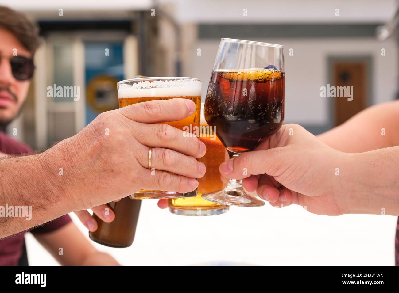 Groupe de personnes faisant un toast avec de la bière et boisson au cola. Banque D'Images