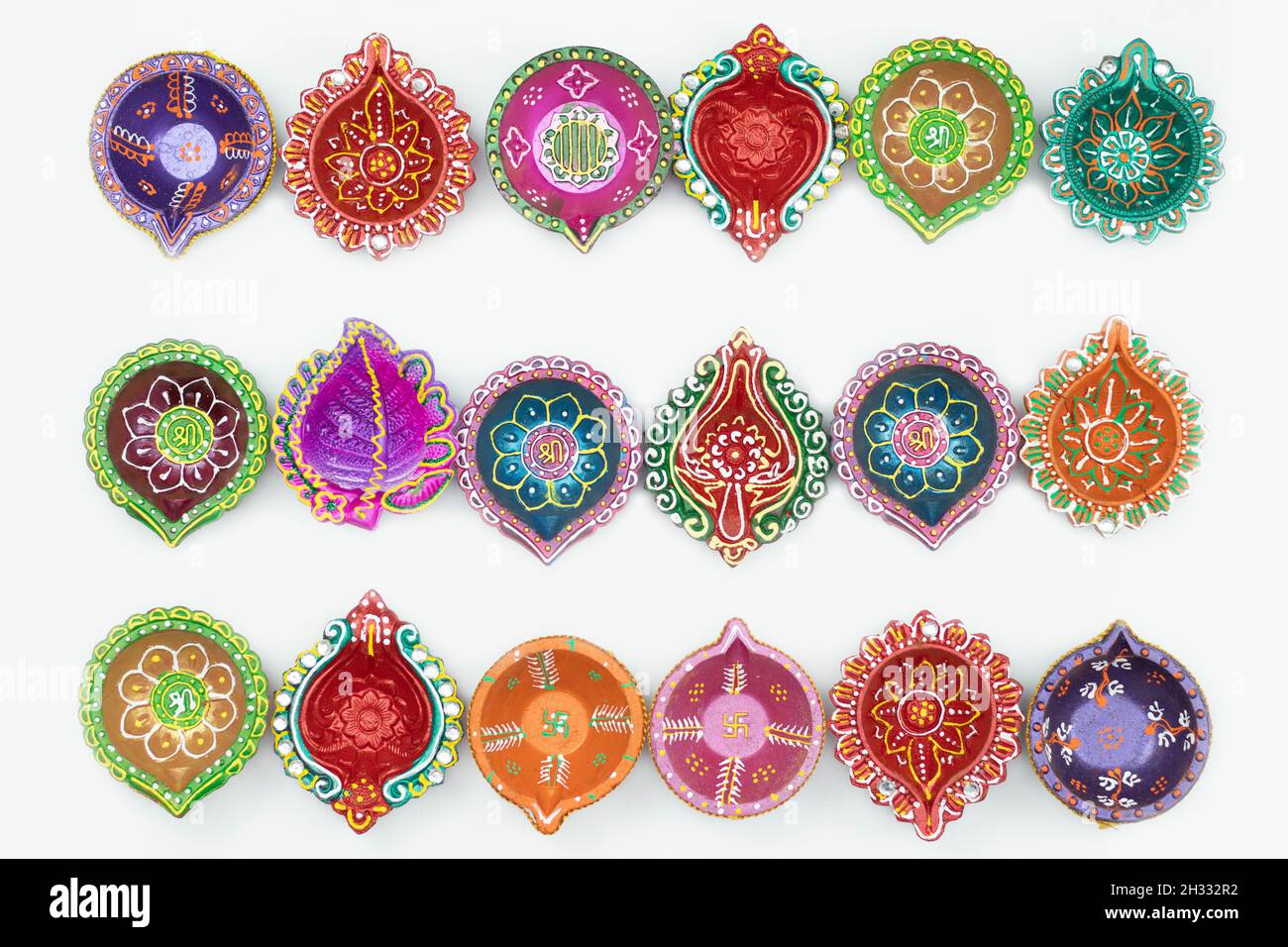 Collection de divers Diya multicolore, profondément arrangé en ligne droite.Isolé sur fond blanc avec espace de copie.Thème pour Diwali, Navratri Pooja, Banque D'Images