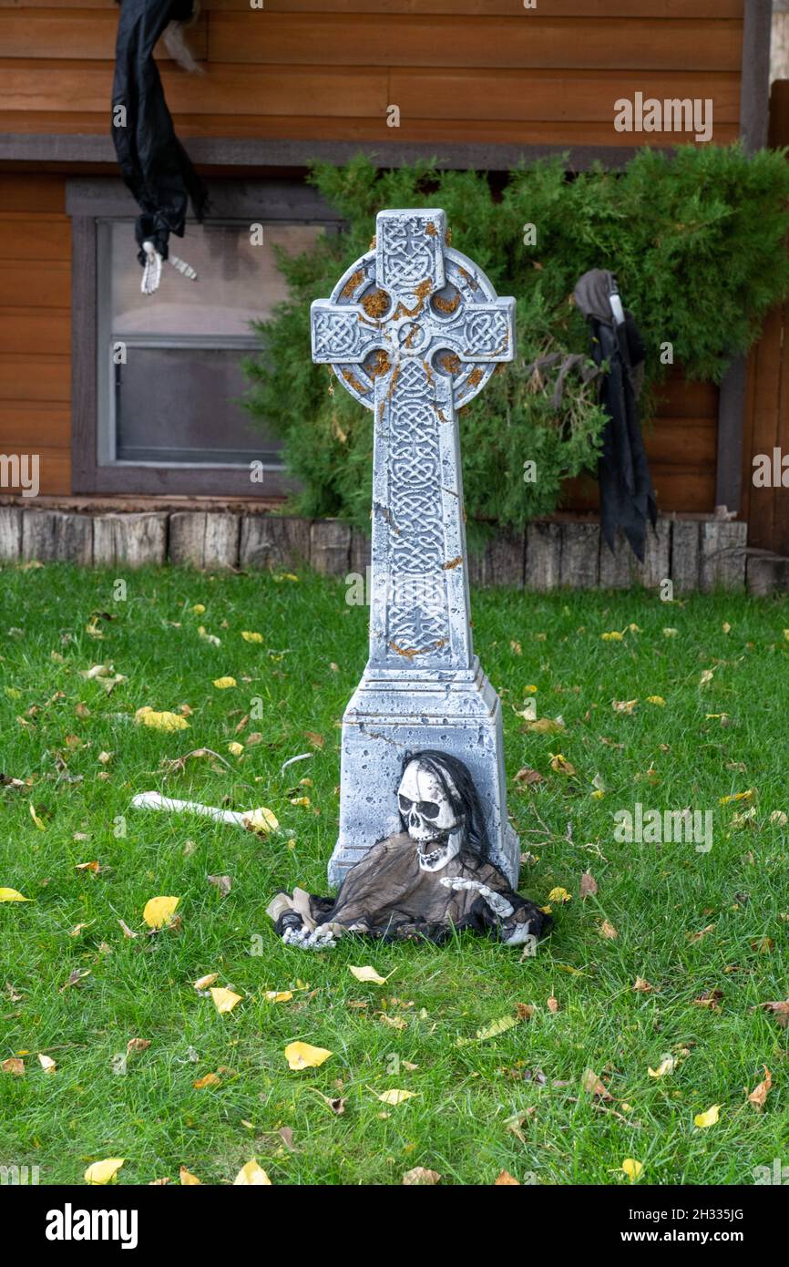 Un squelette de ghoulish émergeant d'une tombe dans une décoration de pelouse d'Halloween. Banque D'Images