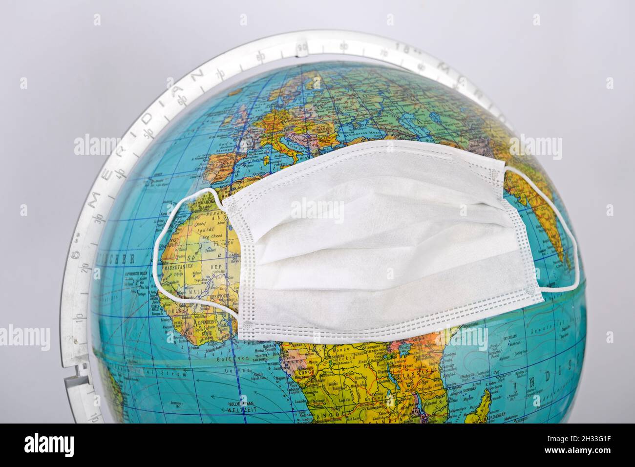 Globus mit OP Maske, Symbolbild Corona - Pandemie Banque D'Images