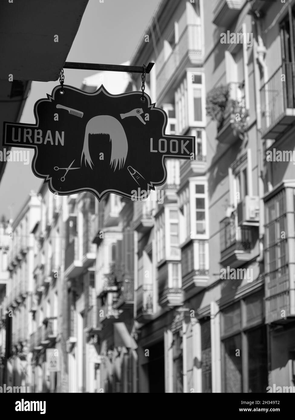 Look urbain, logo de coiffeur, ville de Malaga, Andalousie, Espagne. Banque D'Images