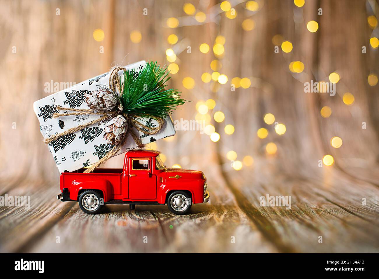 voiture miniature sur fond de bois avec lumière de noël, cadeau de vacances.Concept - solde du nouvel an, achats de Noël.Photo du sujet horizontal avec Chr Banque D'Images