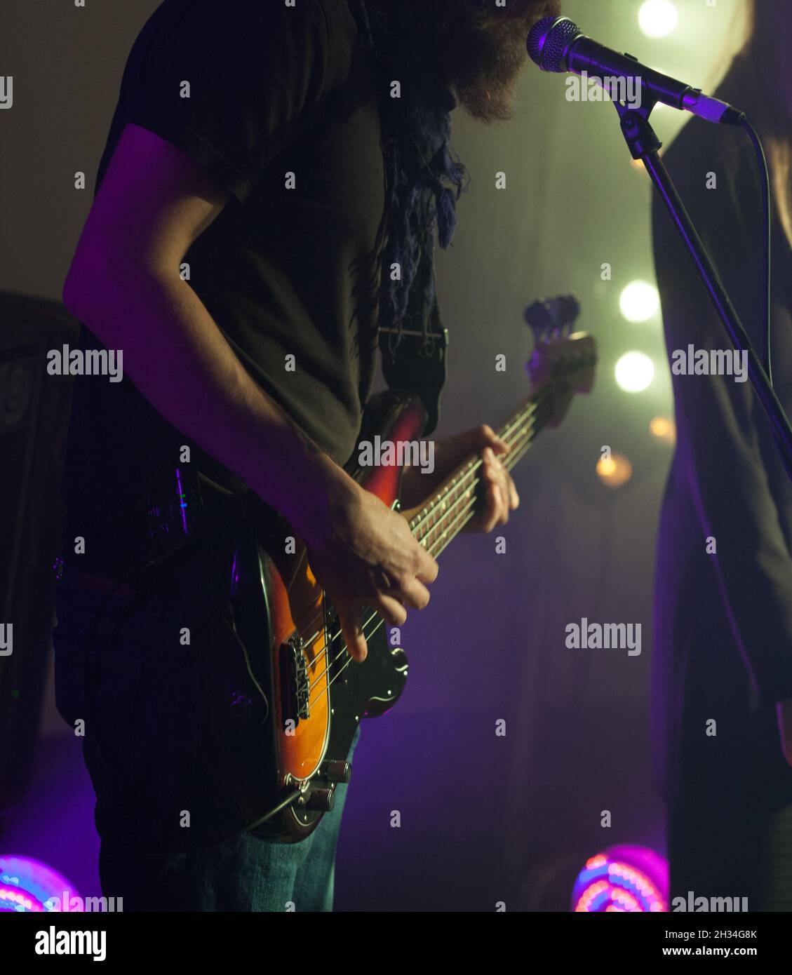 Le guitariste électrique de basse se tient sur scène, photo de gros plan avec mise au point douce Banque D'Images
