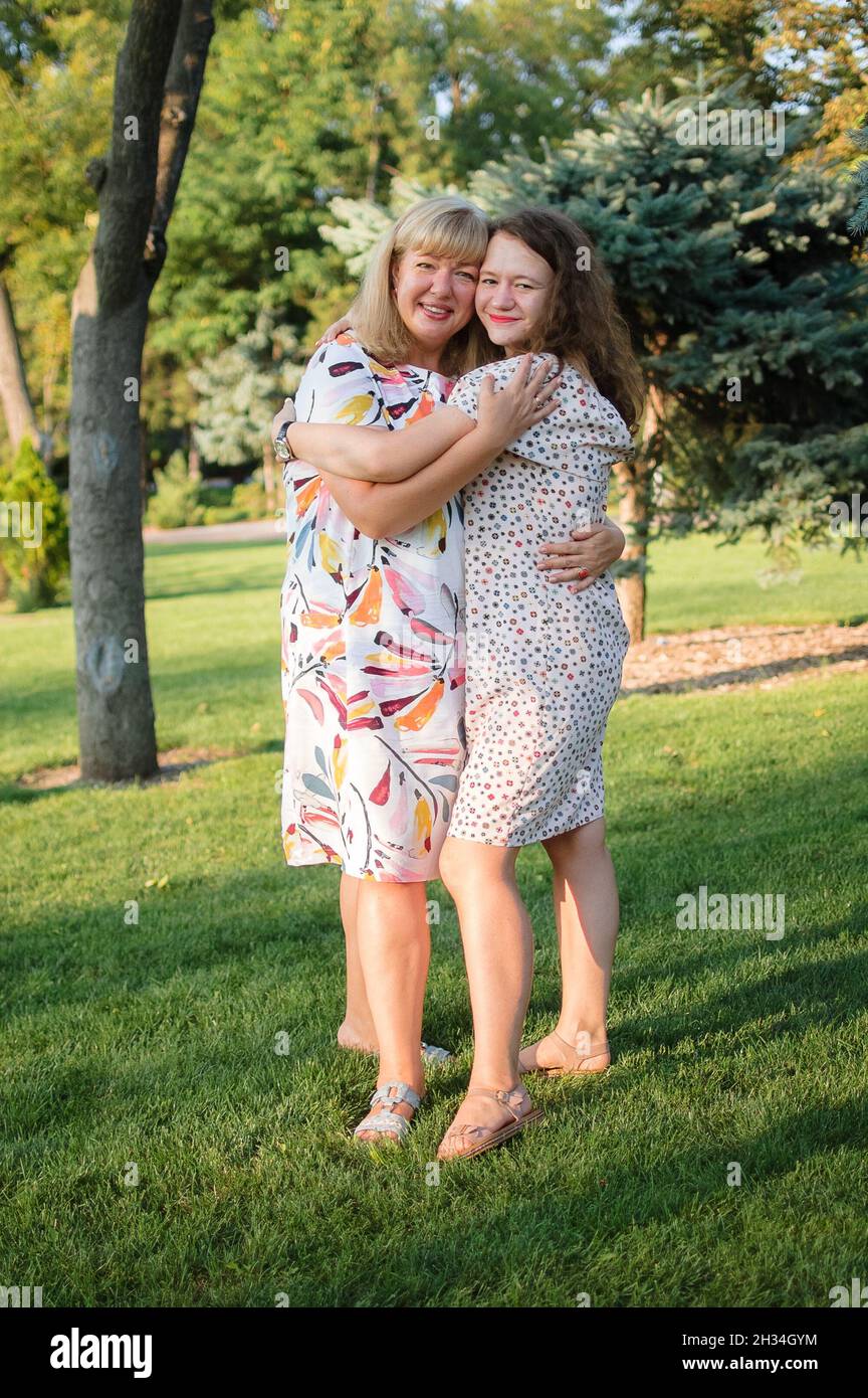Portrait féminin d'une belle mère blonde aux yeux bleus et d'une fille dans le parc en été.Journée en famille, concept de gens heureux Banque D'Images