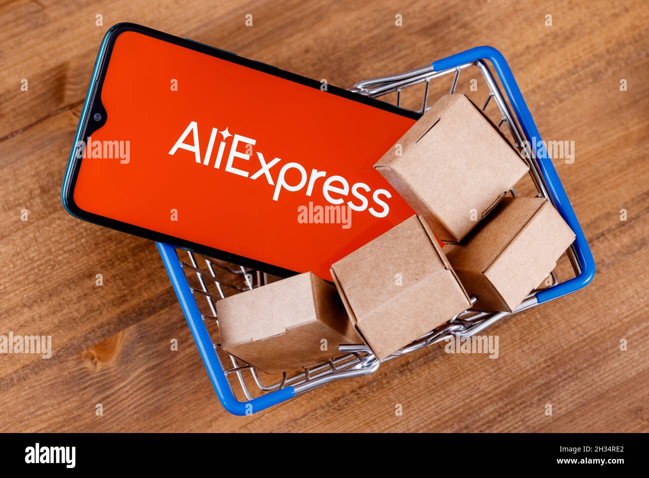 AliExpress est un service de vente au détail en ligne chinois. Smartphone avec logo AliExpress à l'écran et colis dans le panier. Banque D'Images