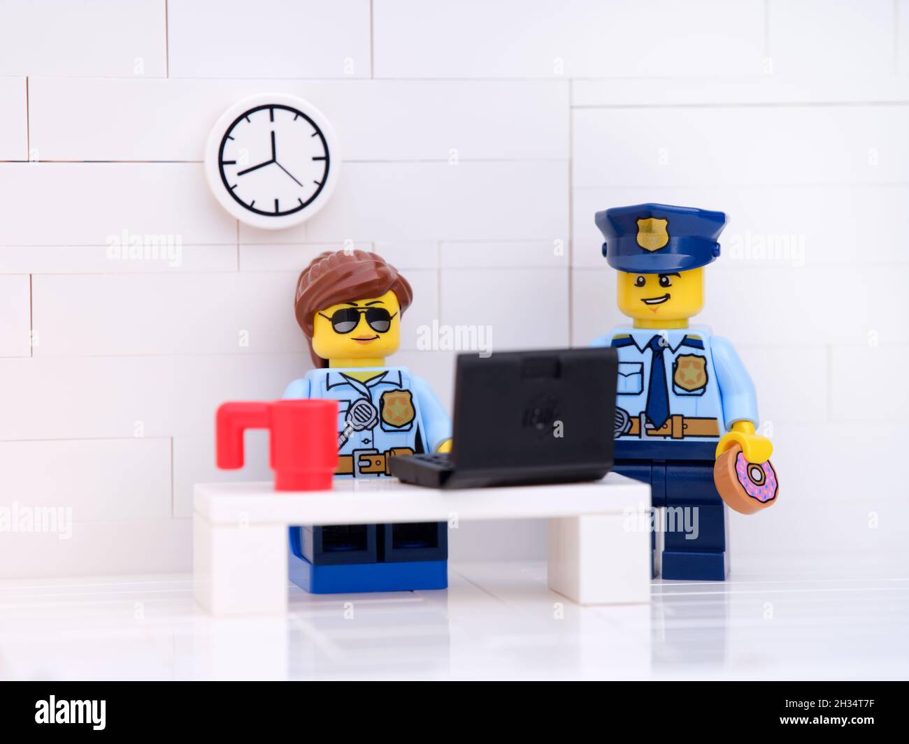 Tambov, Fédération de Russie - 17 octobre 2021 Lego policier et policier dans leur bureau de police travaillant sur un ordinateur portable. Banque D'Images