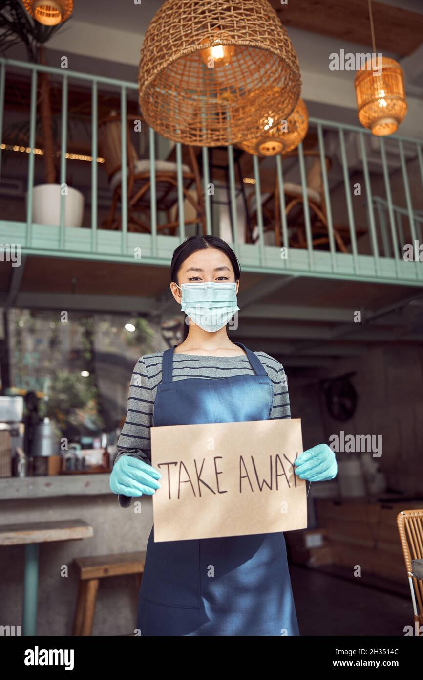 Femme asiatique tenant une bannière avant le café Banque D'Images