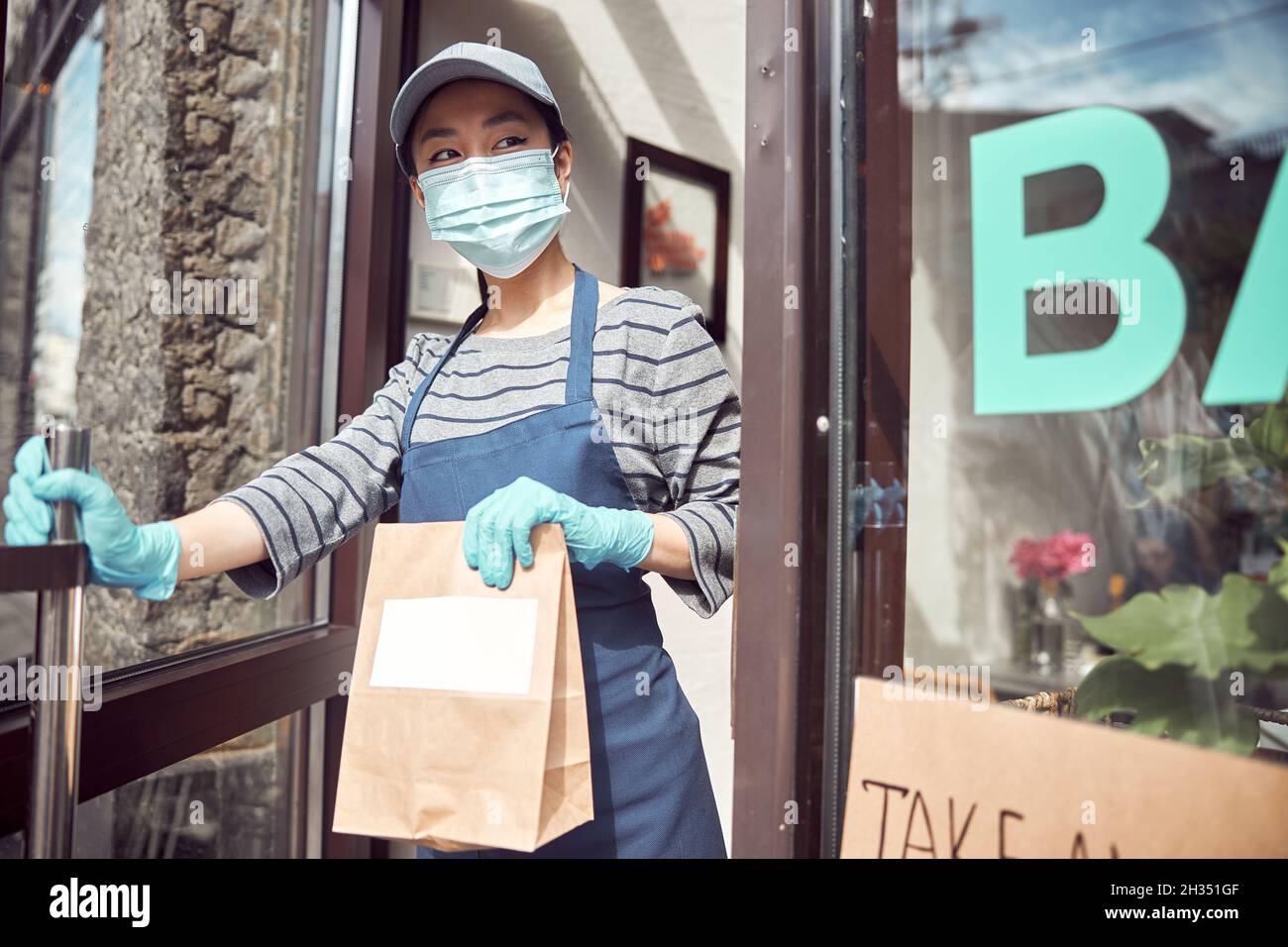 Femme asiatique servant des plats à emporter à l'extérieur du café Banque D'Images
