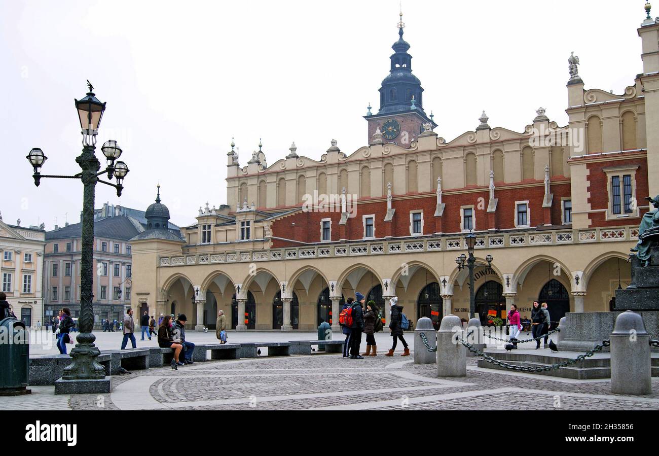 Lors d'une journée hivernale à Cracovie, en Pologne, les gens se meunent autour de la place de la vieille ville, devant la salle de vêtements de Cracovie.Le Cloth Hall se trouve au centre de la plus grande place médiévale d'Europe et abrite le musée Sukiennice ainsi que des étals qui vendent généralement des produits aux visiteurs.La salle en tissu a été reconstruite en 1555 dans le style Renaissance devenant une icône pour la ville et la vieille ville.La place de la vieille ville a été classée au patrimoine mondial de l'UNESCO en 1978. Banque D'Images