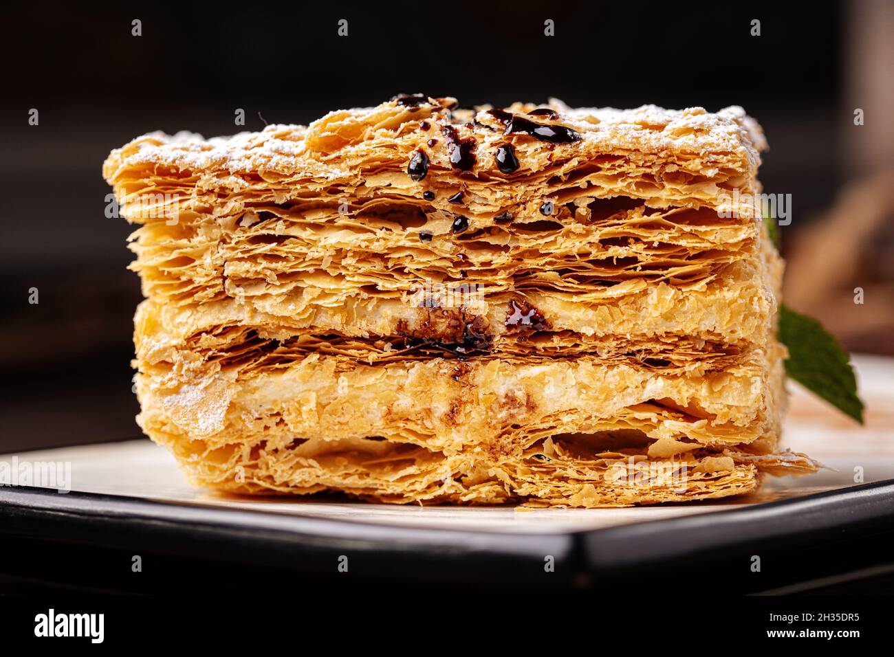 Tranche de gâteau napoléon sur fond en bois Banque D'Images