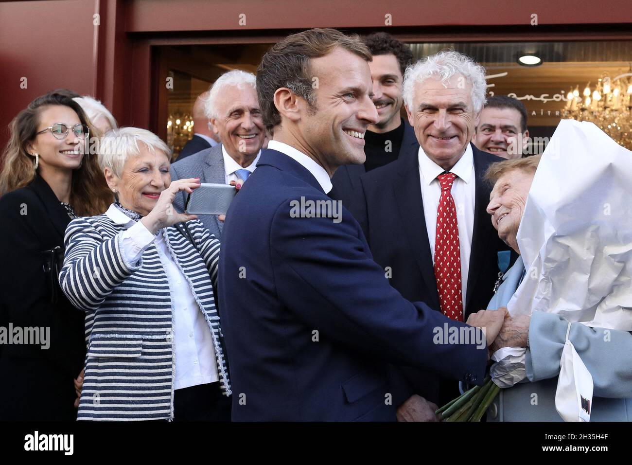 Le président français Emmanuel Macron décerne le 25 octobre 2021 au chocolatier François Pralus, devant un magasin de Pralus à Montbrison, dans le centre-est de la France.Photo de Stephane Lemouton/Pool/ABACAPRESS.COM Banque D'Images