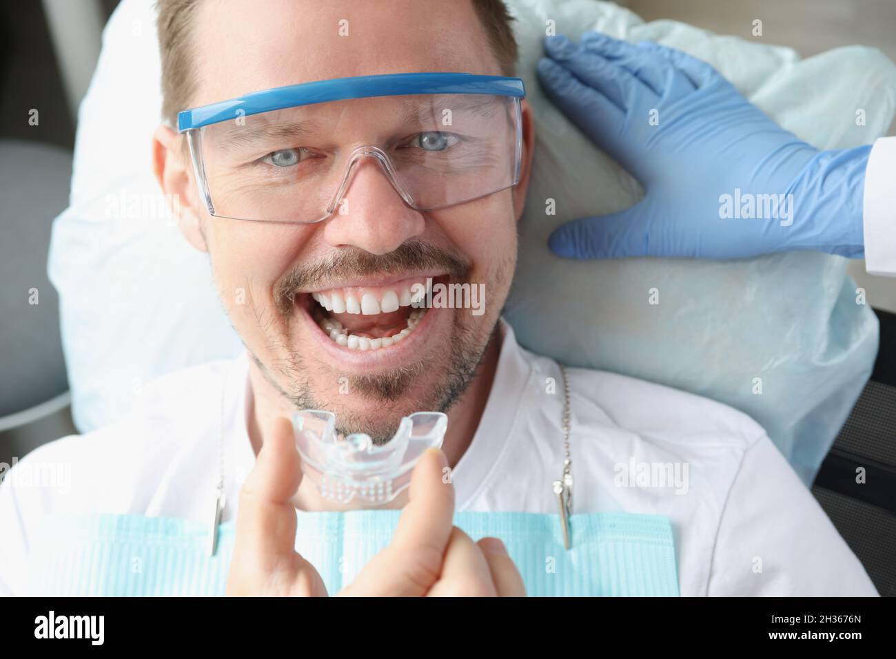 Dentiste médecin insérant une garde de nuit en plastique dans un cabinet  dentaire Photo Stock - Alamy