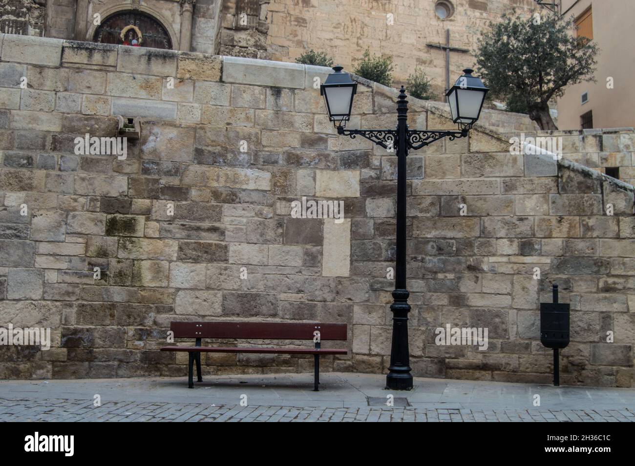 Ancienne lampe de rue anglaise avec banc en bois près d'un bâtiment ancien Banque D'Images