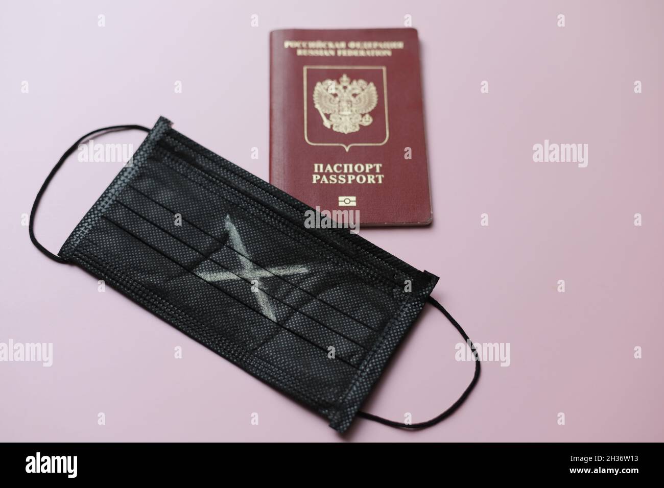 Masque noir avec croix blanche et passeport russe étranger pour voyager.Photo de haute qualité Banque D'Images