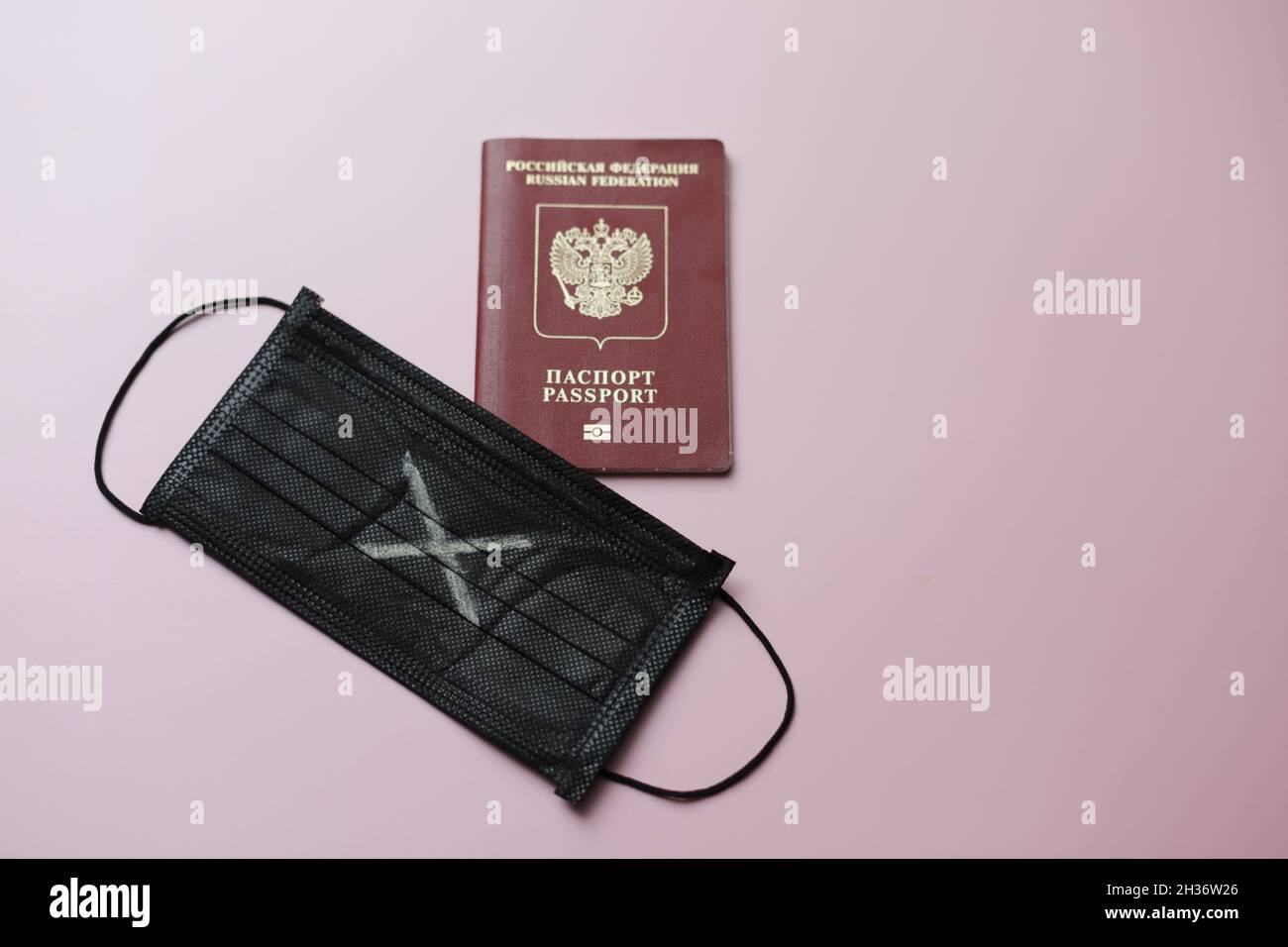 Masque noir avec croix blanche et passeport russe étranger pour voyager.Photo de haute qualité Banque D'Images