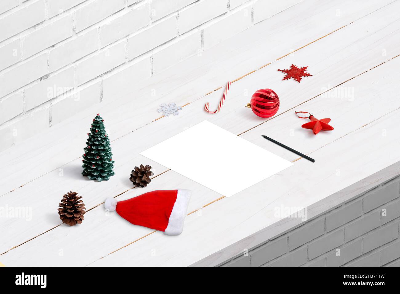 Écrire la lettre au concept du Père Noël.Une feuille de papier vierge sur le bureau, entourée de décorations de Noël. Banque D'Images