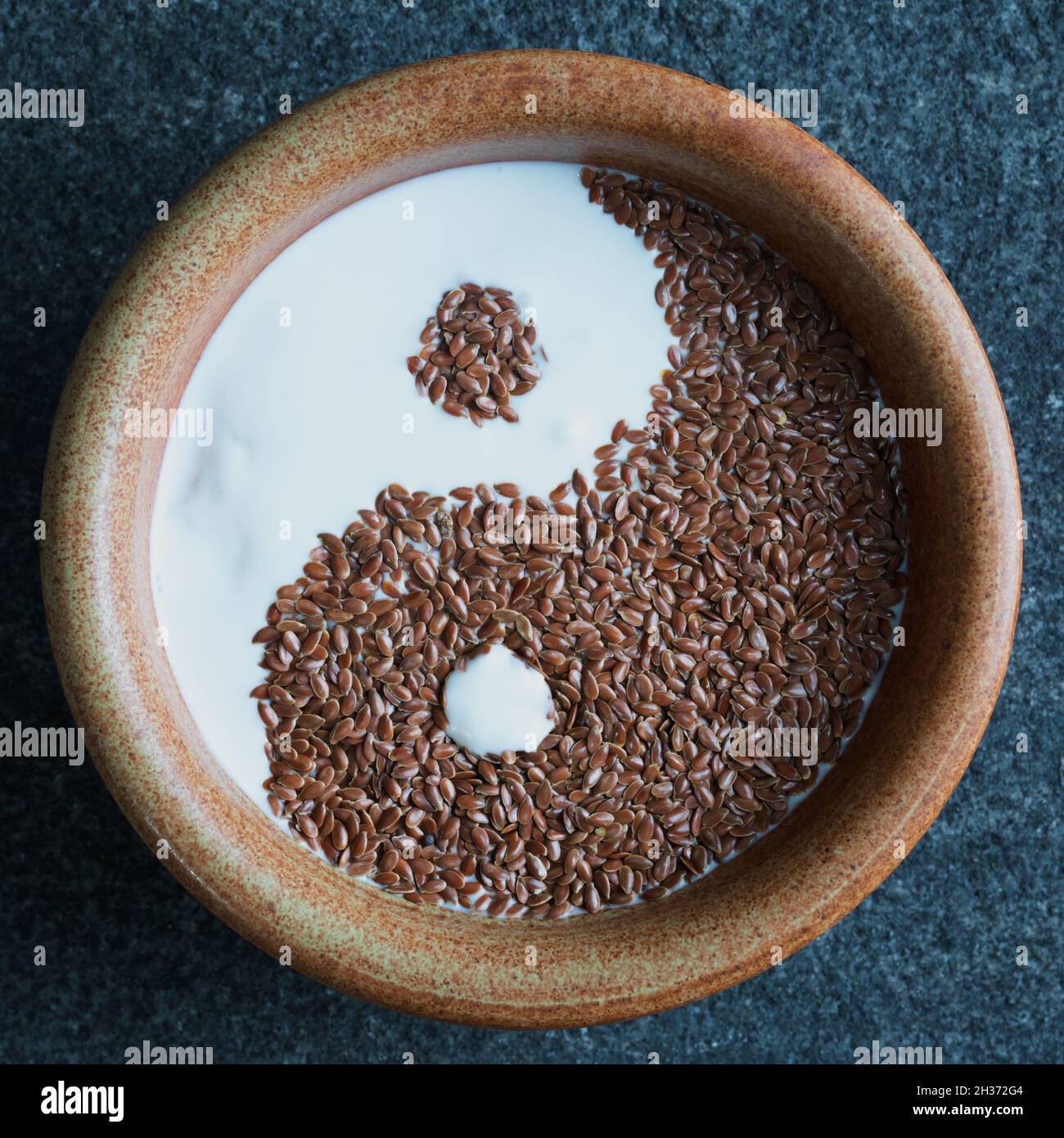 Porridge de petit déjeuner sain avec de l'avoine coupée en acier, de la crème de noix de coco et des graines de lin dans le style Ying Yang Banque D'Images
