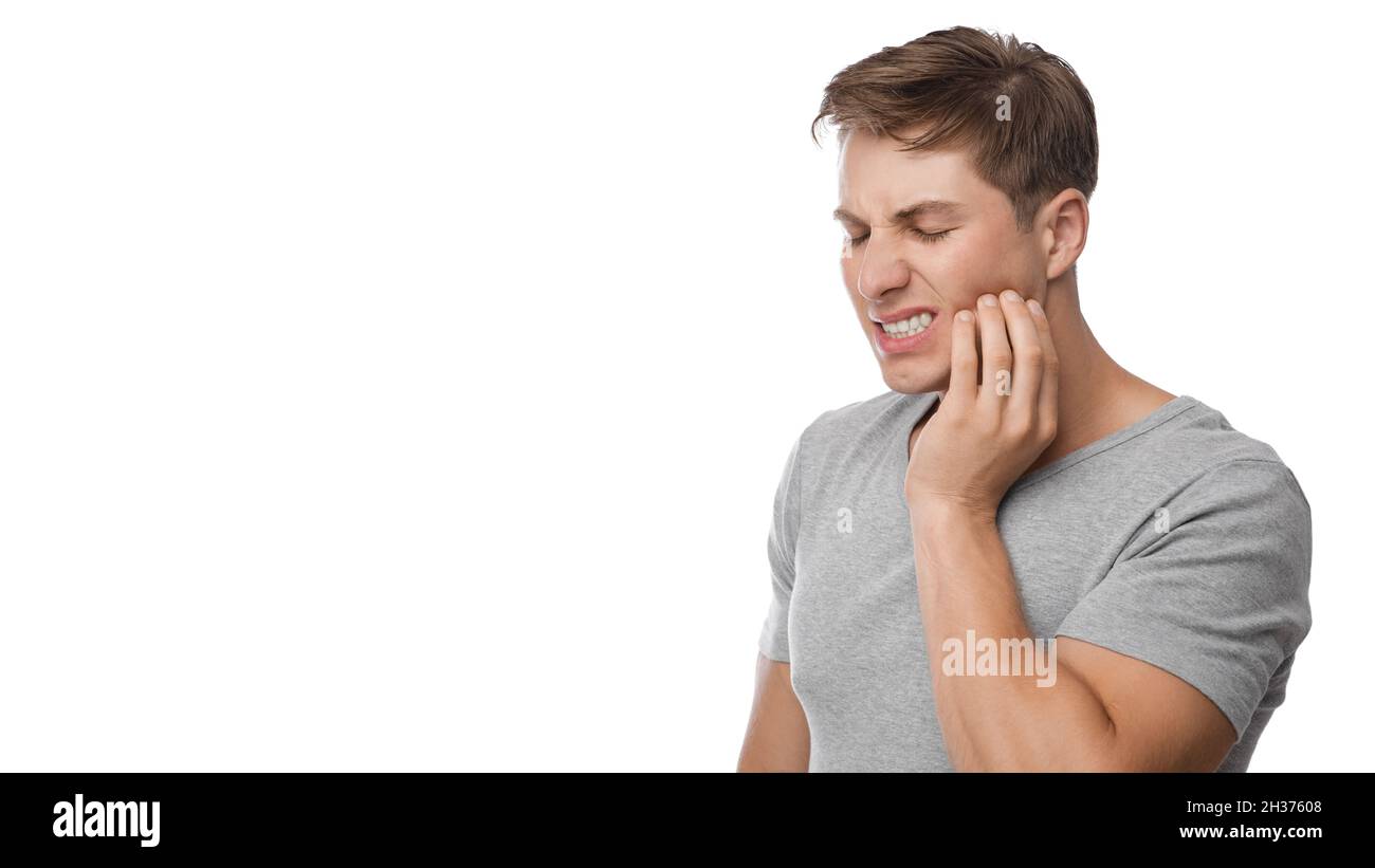 Un homme européen millénaire déjumelé souffrant de maux de dents, appuie main à mâchoire, montre son mécontentement Banque D'Images