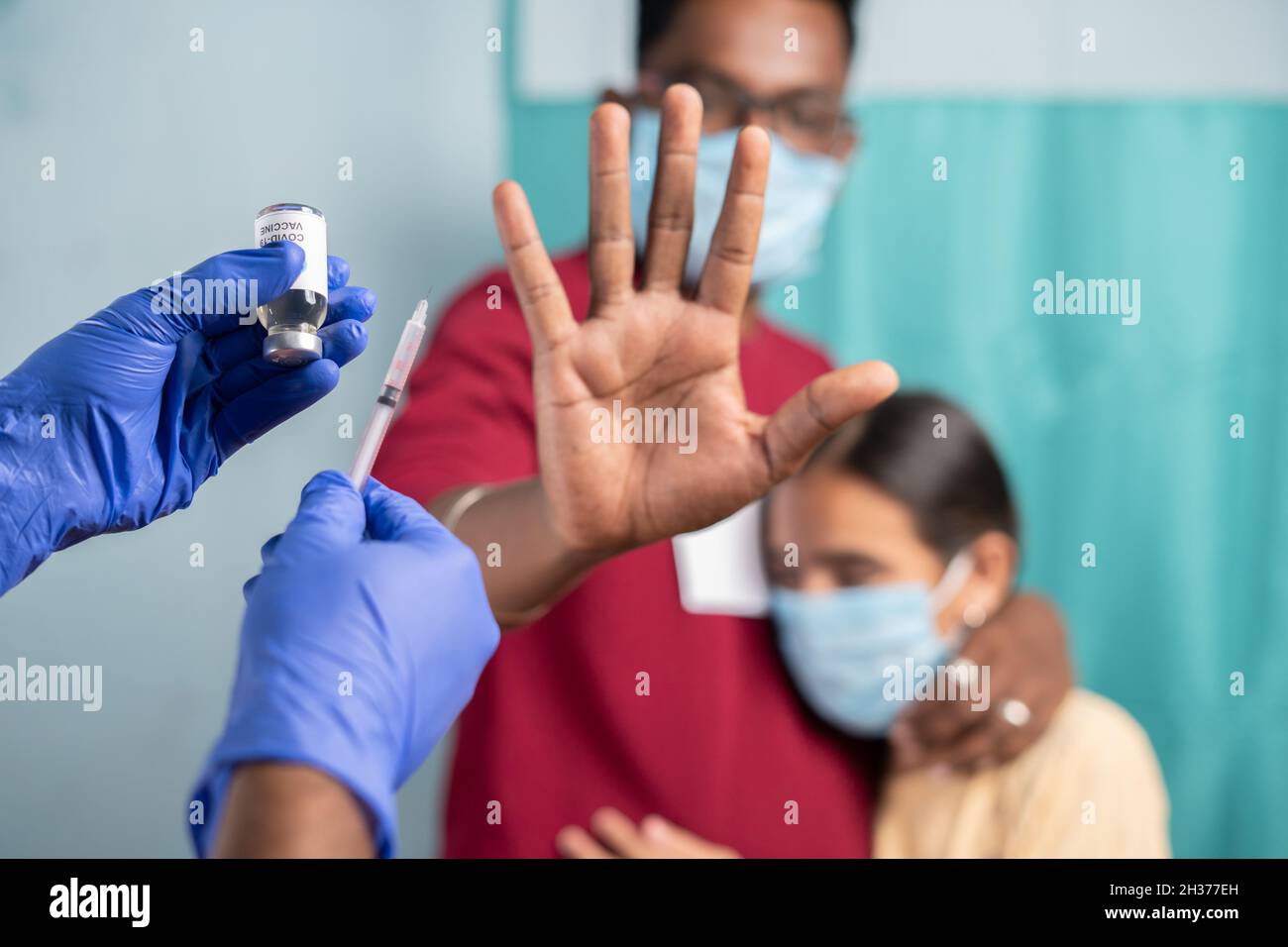 Accent sélectif sur la bouteille de vaccination du coronavirus - concept de l'hésitation des parents à l'égard du vaccin pour les enfants, en montrant en disant non ou en mettant fin au geste pour le vaccin Banque D'Images