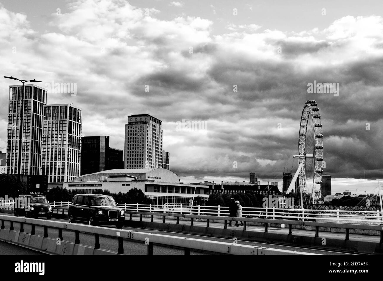 Vue sur l'immeuble de l'appartement et du bureau et le London Eye depuis le pont de Waterloo avec People and taxi’s Crossing Banque D'Images