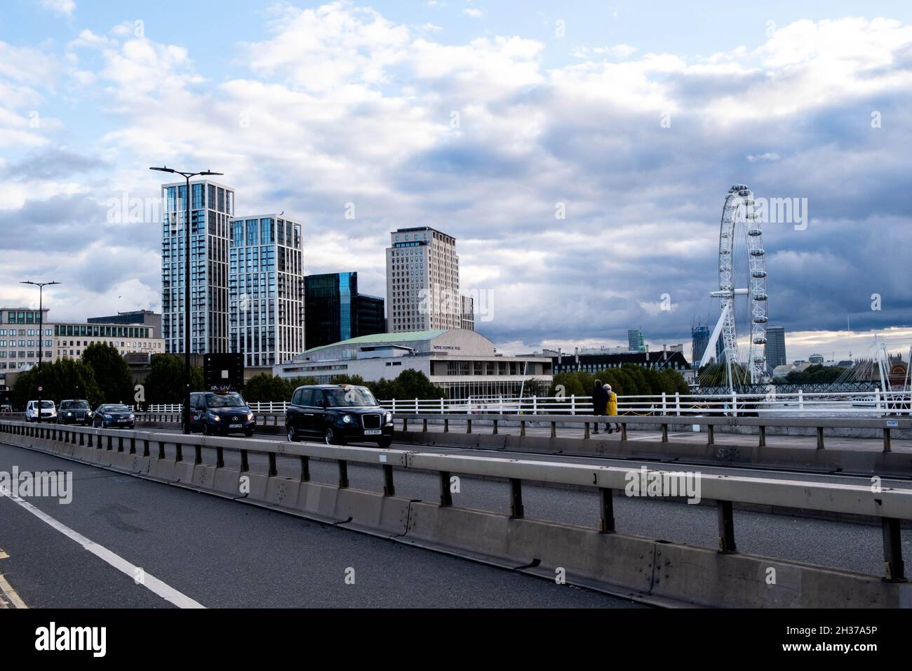 Vue sur l'immeuble de l'appartement et du bureau et le London Eye depuis le pont de Waterloo avec People and taxi’s Crossing Banque D'Images