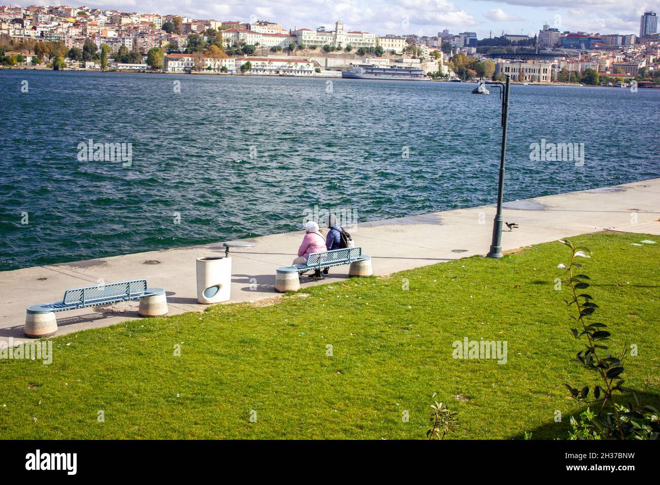 Fatih,Istanbul,Turquie-octobre-mercredi-2021: Femmes en deux chapeaux assises sur un banc près de la Corne d'Or Banque D'Images