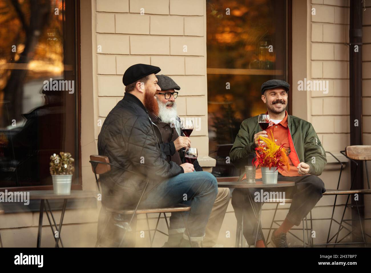 Amis ayant une réunion au café le chaud jour d'automne.Boire du vin rouge Banque D'Images