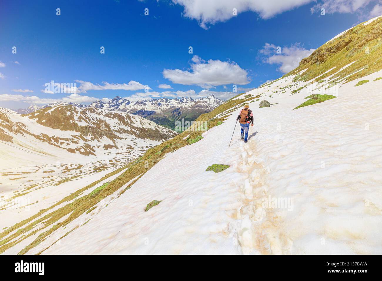 Homme suisse marchant dans la neige sur le sentier glacé de Muottas Muragl en Suisse.Excursion populaire en montagne dans la neige dans le canton des Grisons en Suisse. Banque D'Images