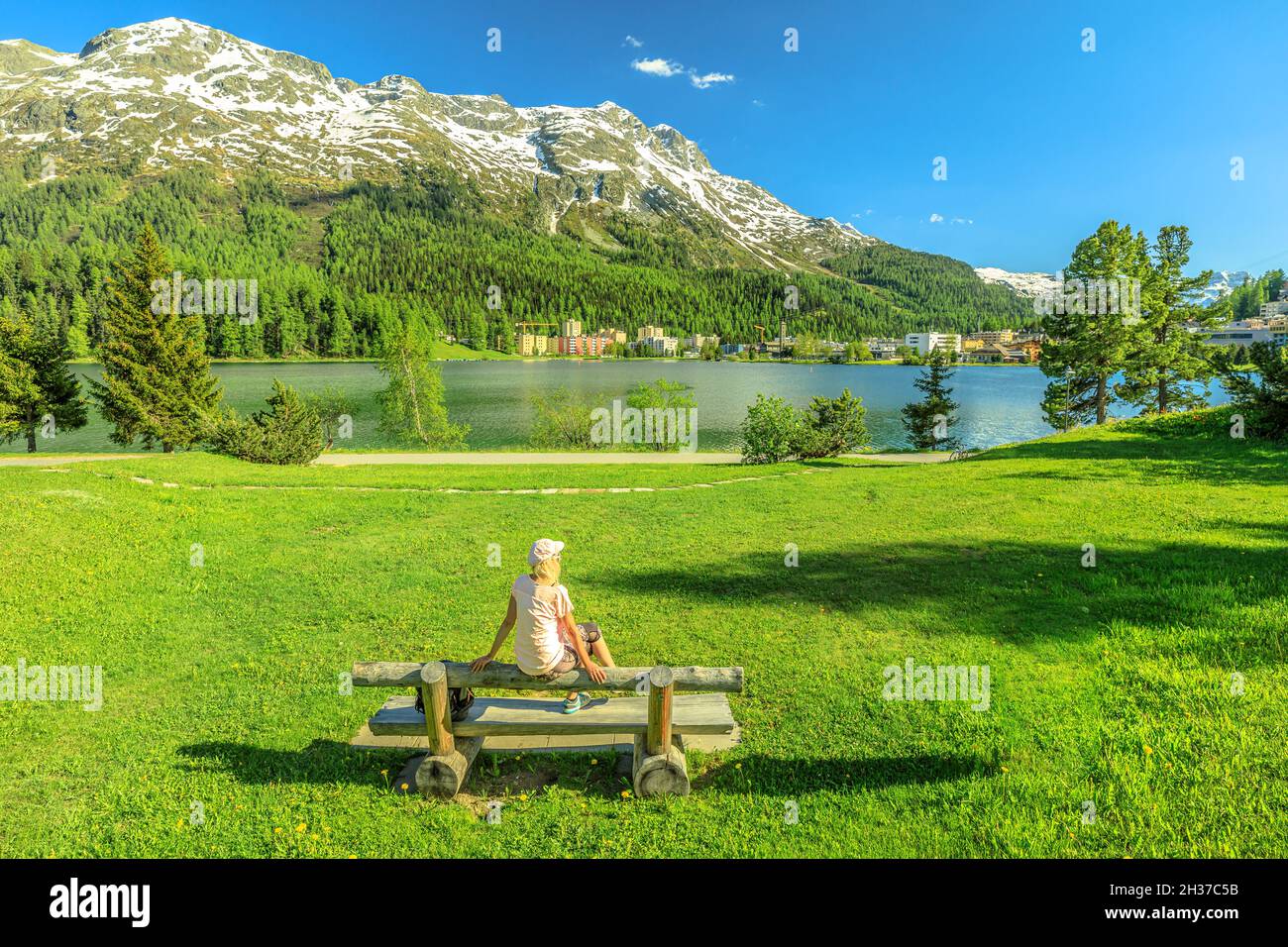 Femme de tourisme assise dans le parc de Saint-Moritz près du lac de Saint-Moritz en Suisse.Le lac de Saint-Moritz dans le canton des Grisons, dans la région de Maloja. Banque D'Images