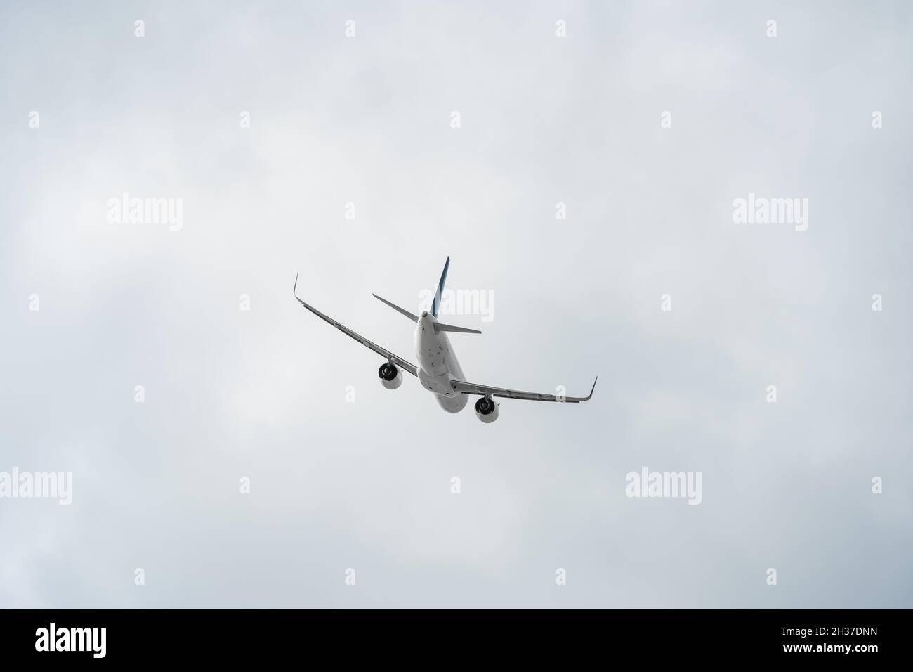 Vue arrière d'un avion passager blanc en gros plan contre un ciel gris avec espace de copie.Le plan se dirige vers la droite Banque D'Images