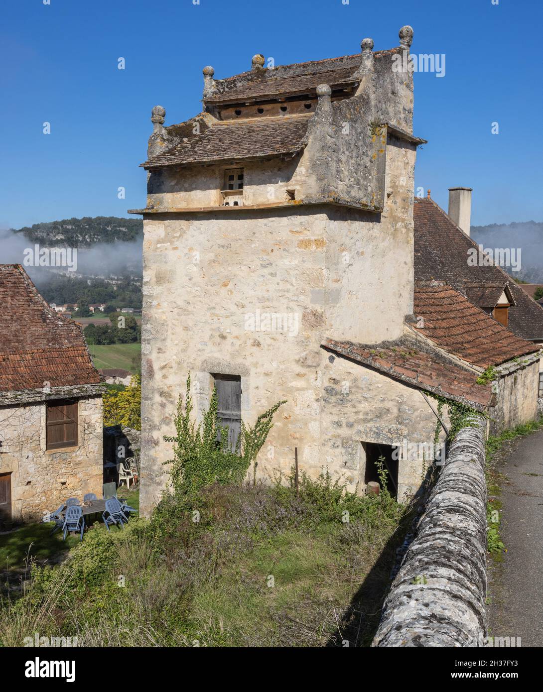 Pigeonnier en pierre avec toit en tuiles et finals en pierre dans le hameau de la vallée du Lot de Calvignac, France Banque D'Images