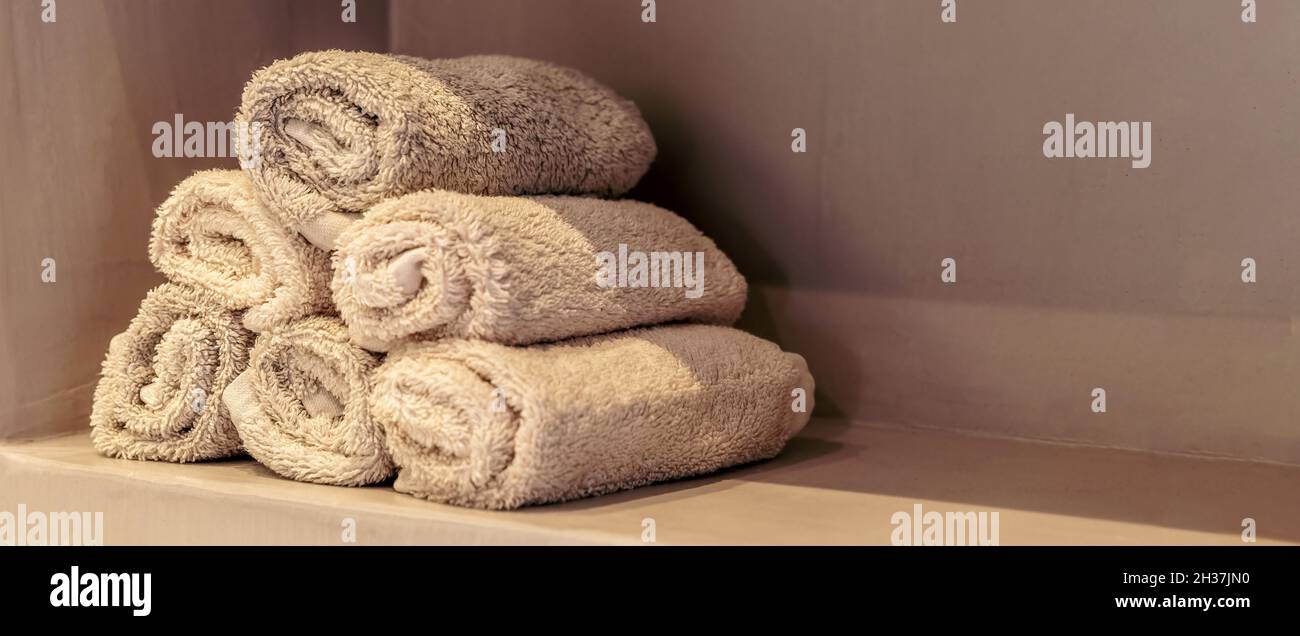 Serviettes de bain, décoration intérieure moderne de la salle de bien-être spa.Nettoyer les essuie-mains empilés sur une vue rapprochée de tablette, une bannière, un espace de copie et une zone de temp Banque D'Images