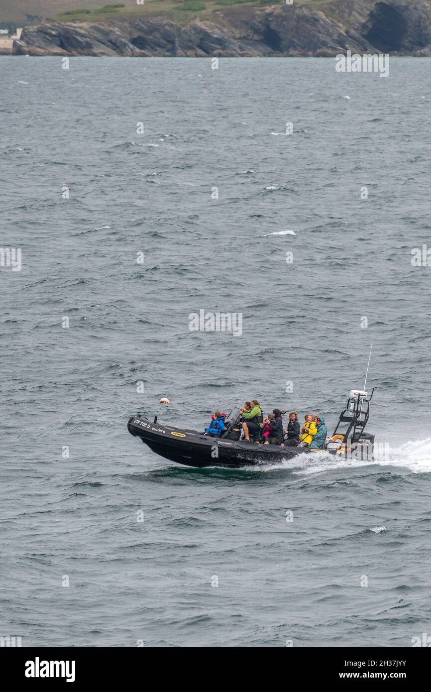 Une CÔTE de bateau rigide et inflatable remplie de passagers de vacanciers à pleine vitesse dans la mer bâclée de Newquay Bay, dans les Cornouailles. Banque D'Images