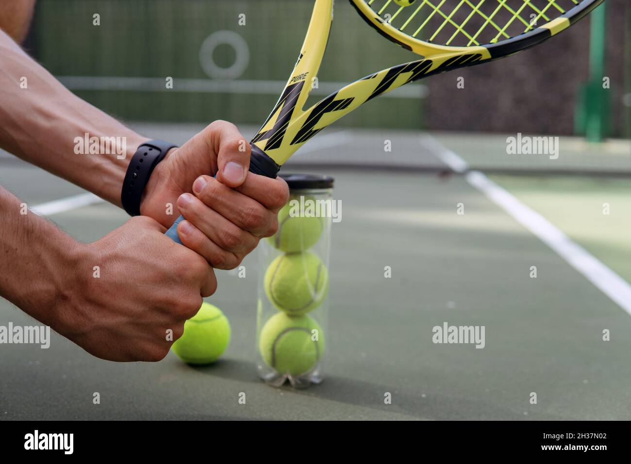 gros plan. mains de sexe masculin tenant une raquette et des balles de  tennis. bali Photo Stock - Alamy