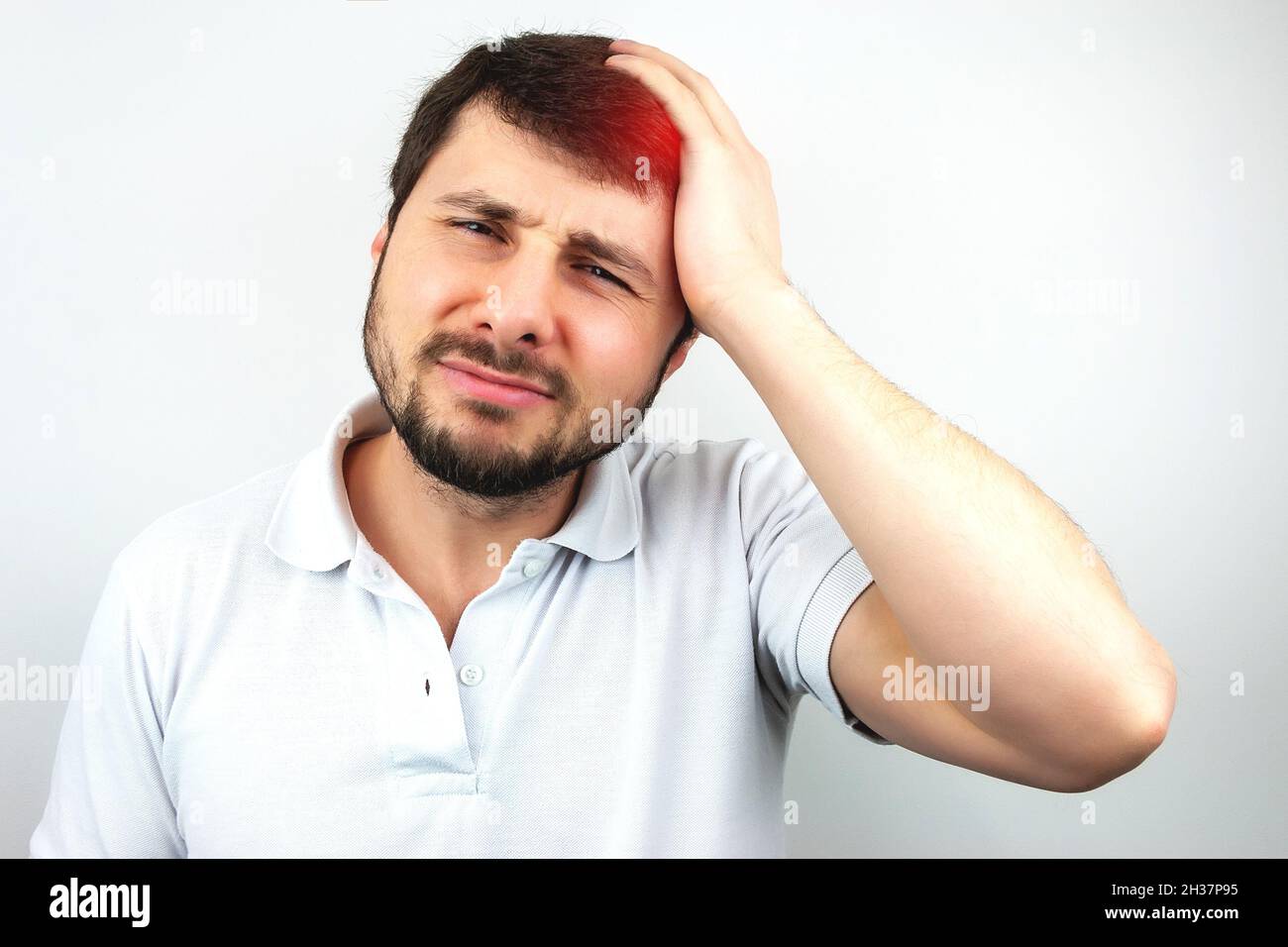 Beau barbu homme tenant sa tête avec sa main et souffrant de maux de tête ou de migraine sur fond blanc Banque D'Images