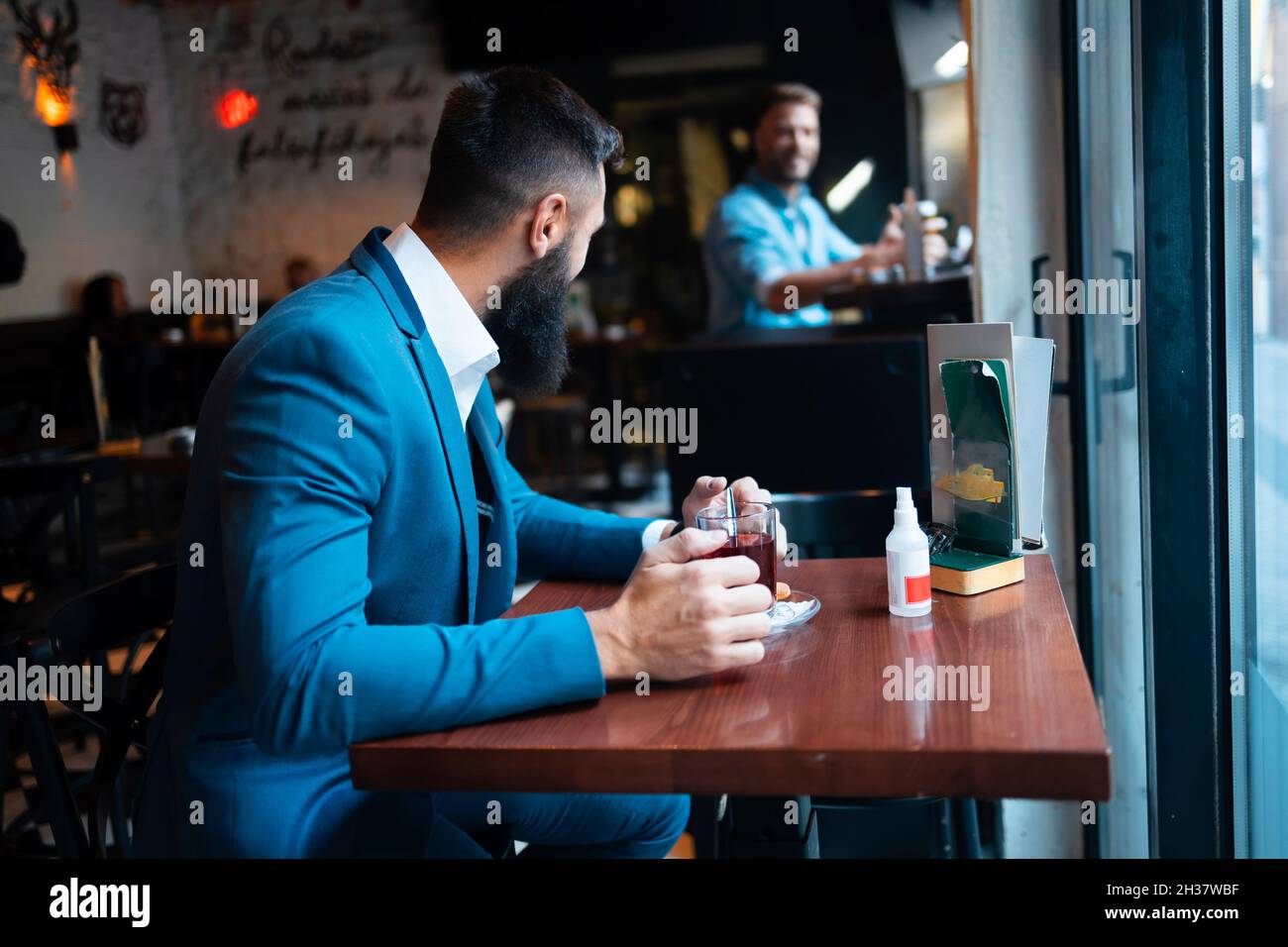 Deux amis de sexe masculin discutant dans un bar Banque D'Images
