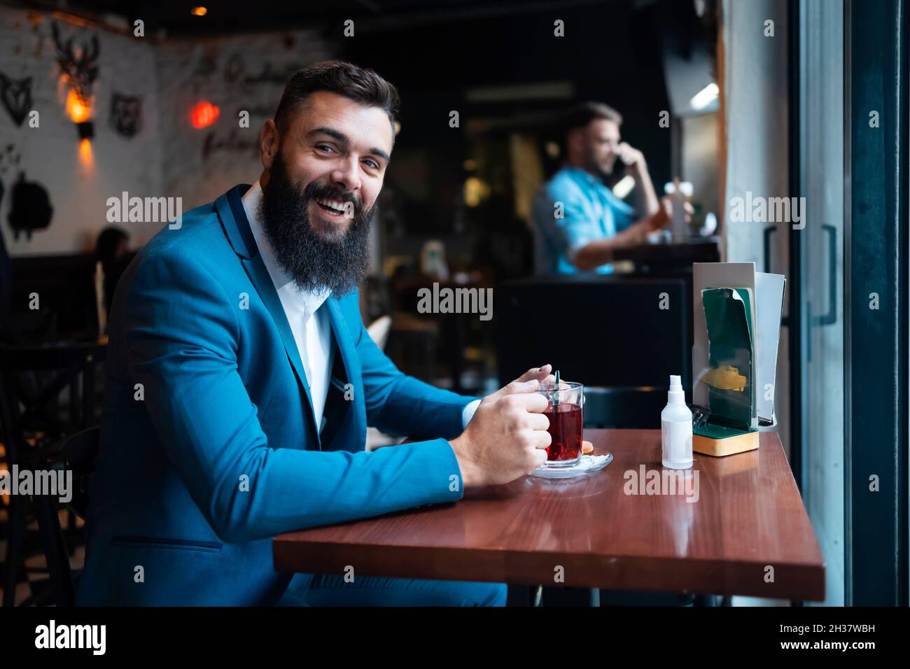 Un homme d'affaires qui boit son thé du matin dans un bar Banque D'Images