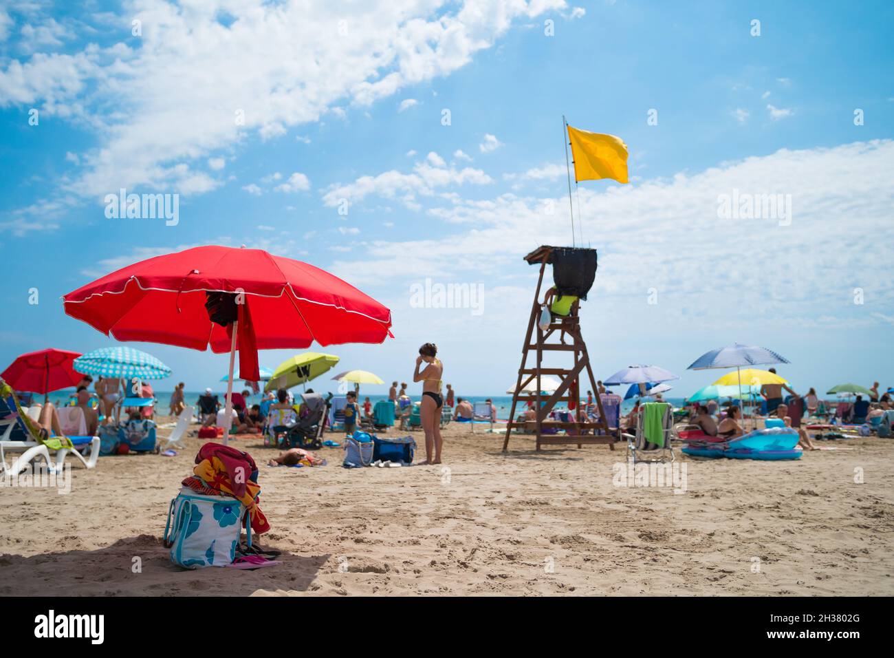 VALENCE, ESPAGNE - 22 septembre 2021 : Communauté Valencienne, Espagne - août 2021.Scène d'été à la plage.Touristes et parasols autour de poste de Lifeguard avec Banque D'Images