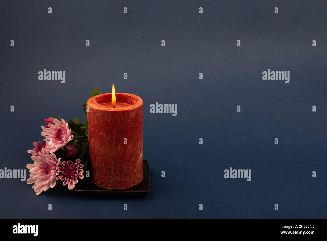 Composition des fleurs et bougie brûlante pour toutes les âmes de jour.Convient également aux funérailles, au deuil, au deuil. Banque D'Images