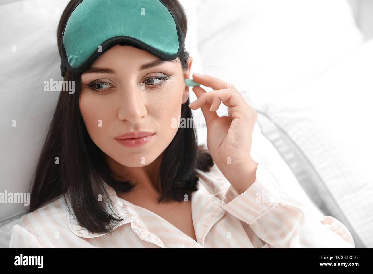 Jeune femme avec des bouchons d'oreilles dans la chambre Banque D'Images