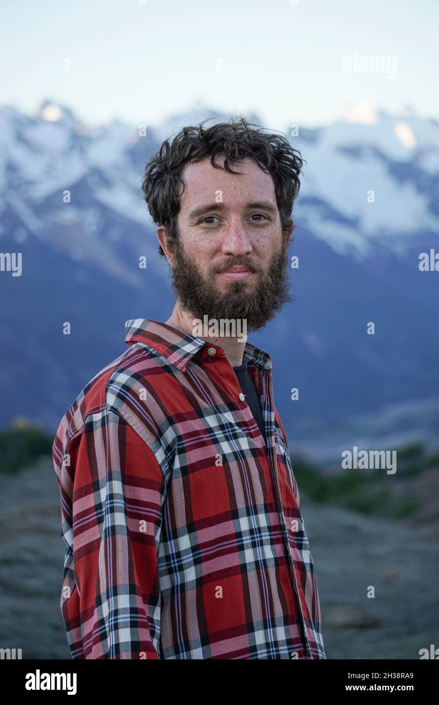 Jeune homme adulte avec chemise rouge de bûcheron dans les montagnes Banque D'Images