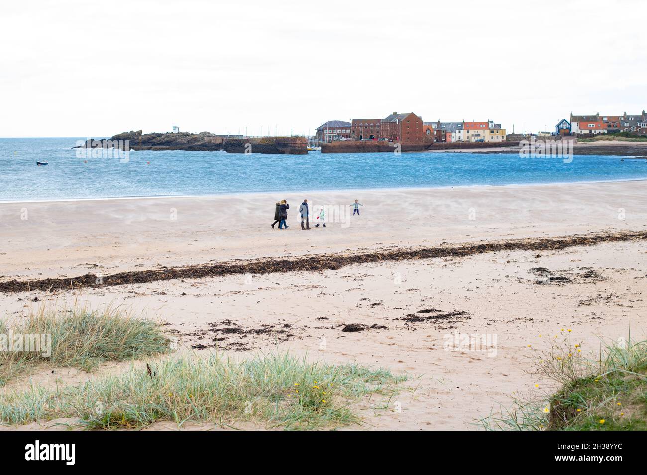 West Beach, North Berwick, Écosse, Royaume-Uni - groupe familial marchant le long de la plage par temps venteux Banque D'Images