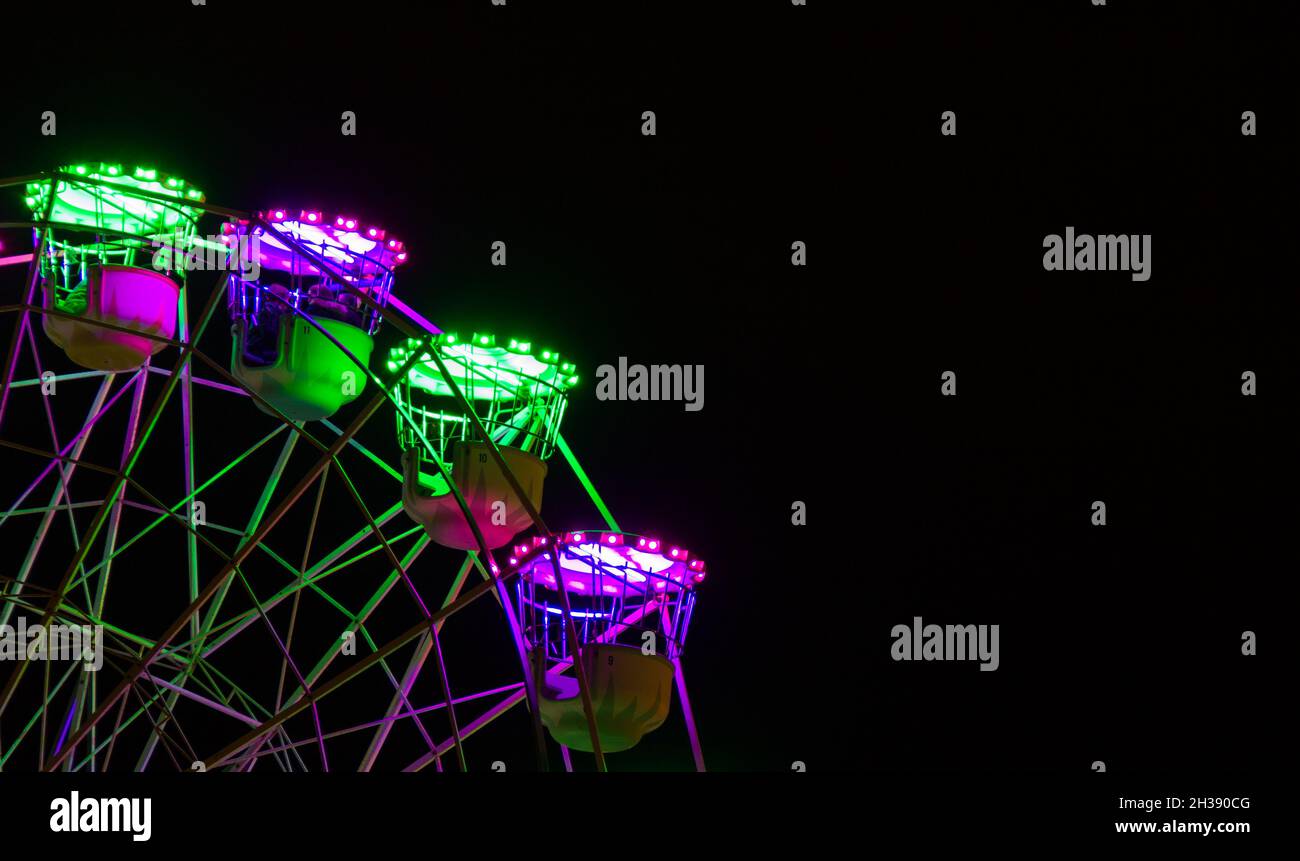 Gros plan sur la grande roue la nuit avec des lumières colorées la saison de Noël à San Sebastian, Espagne Banque D'Images