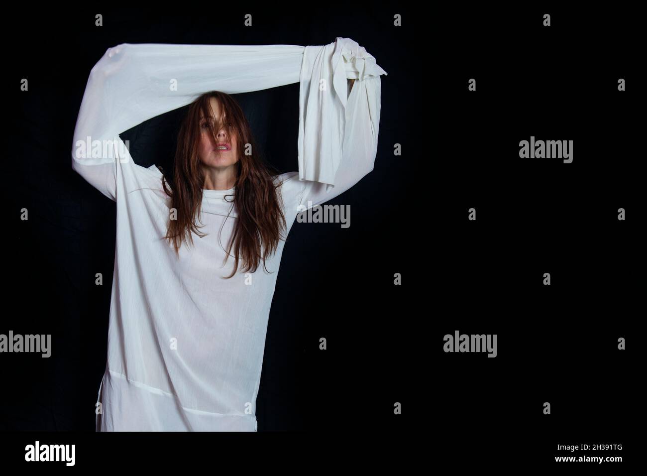 Concept des problèmes mentaux et de la santé mentale.Portrait d'une femme dans un blouson blanc avec un regard fou triste Banque D'Images