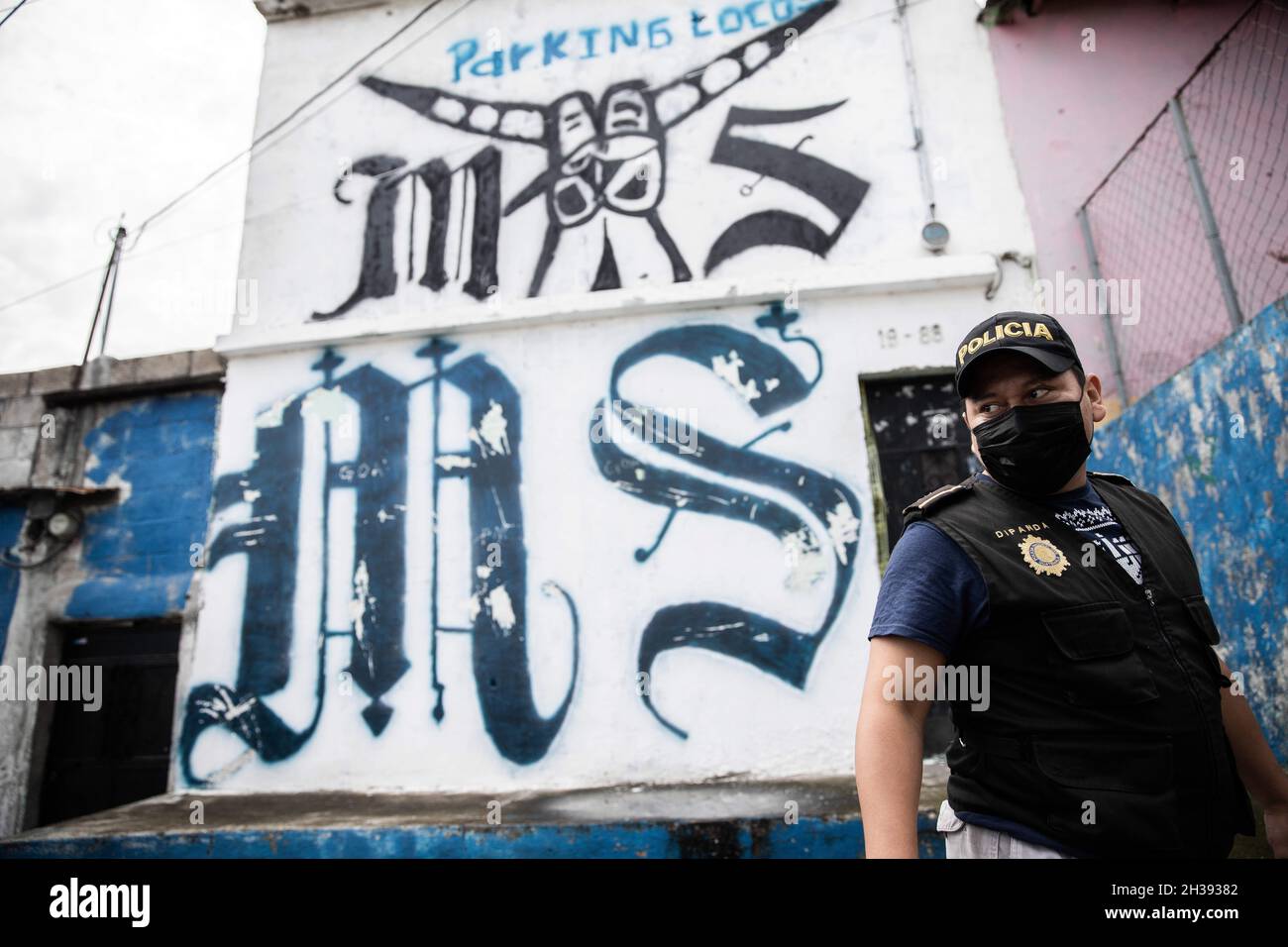 Guatemala, Guatemala.2 juillet 2021.Un membre de la Policia Nacional civil guatémaltèque se trouve à côté des graffitis des gangs devant la seule voie vers le territoire de la bande MS-13.Cette fois-ci, ils ne pouvaient pas entrer car ce territoire a apparemment une base solide de communauté MS-13.« ils auraient pris des photos immédiatement après nous », a déclaré un policier.(Image de crédit : © David Tesinsky/ZUMA Press Wire) Banque D'Images