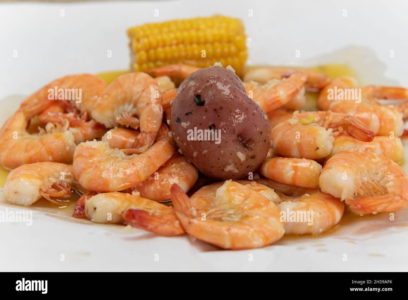Pot bouilli de crevettes assaisonnées et prêtes à peler et à manger avec des pommes de terre et du maïs. Banque D'Images