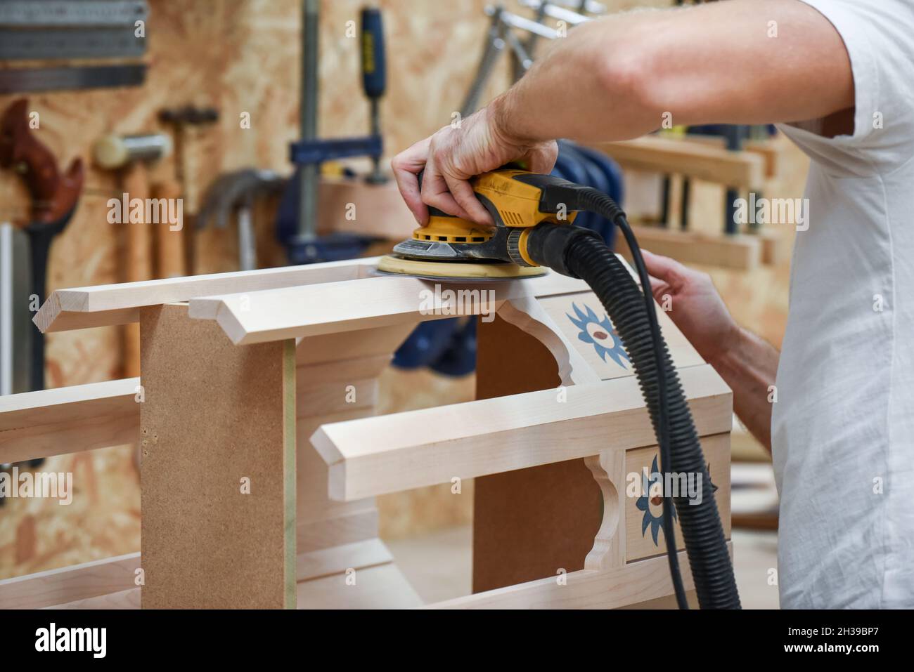 Un homme utilisant une ponceuse électrique à outils électriques pour  fabriquer du bois dans le commerce de menuiserie Photo Stock - Alamy
